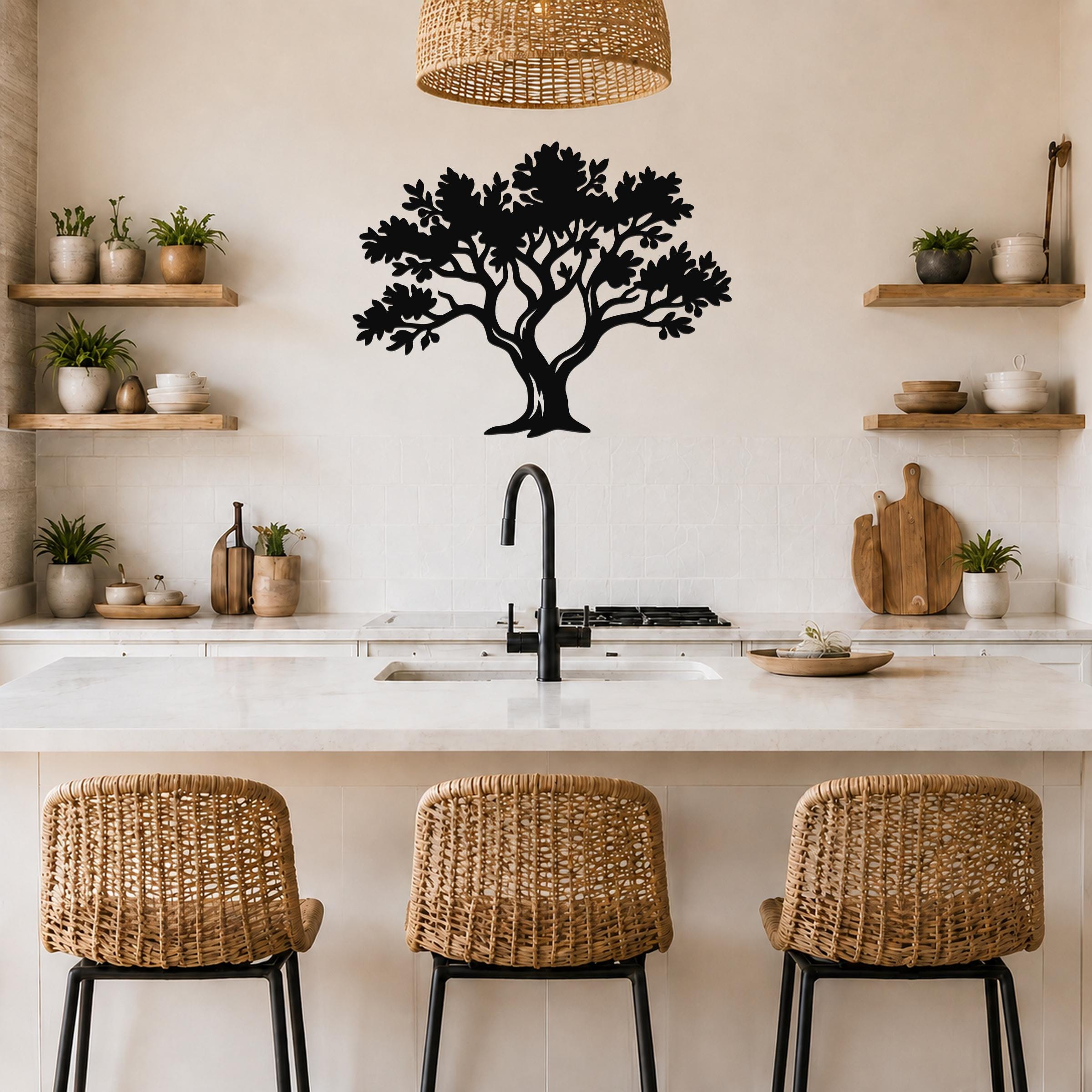 Black metal tree wall art with intricate branch and leaf cutouts, mounted on a kitchen wall above a counter.