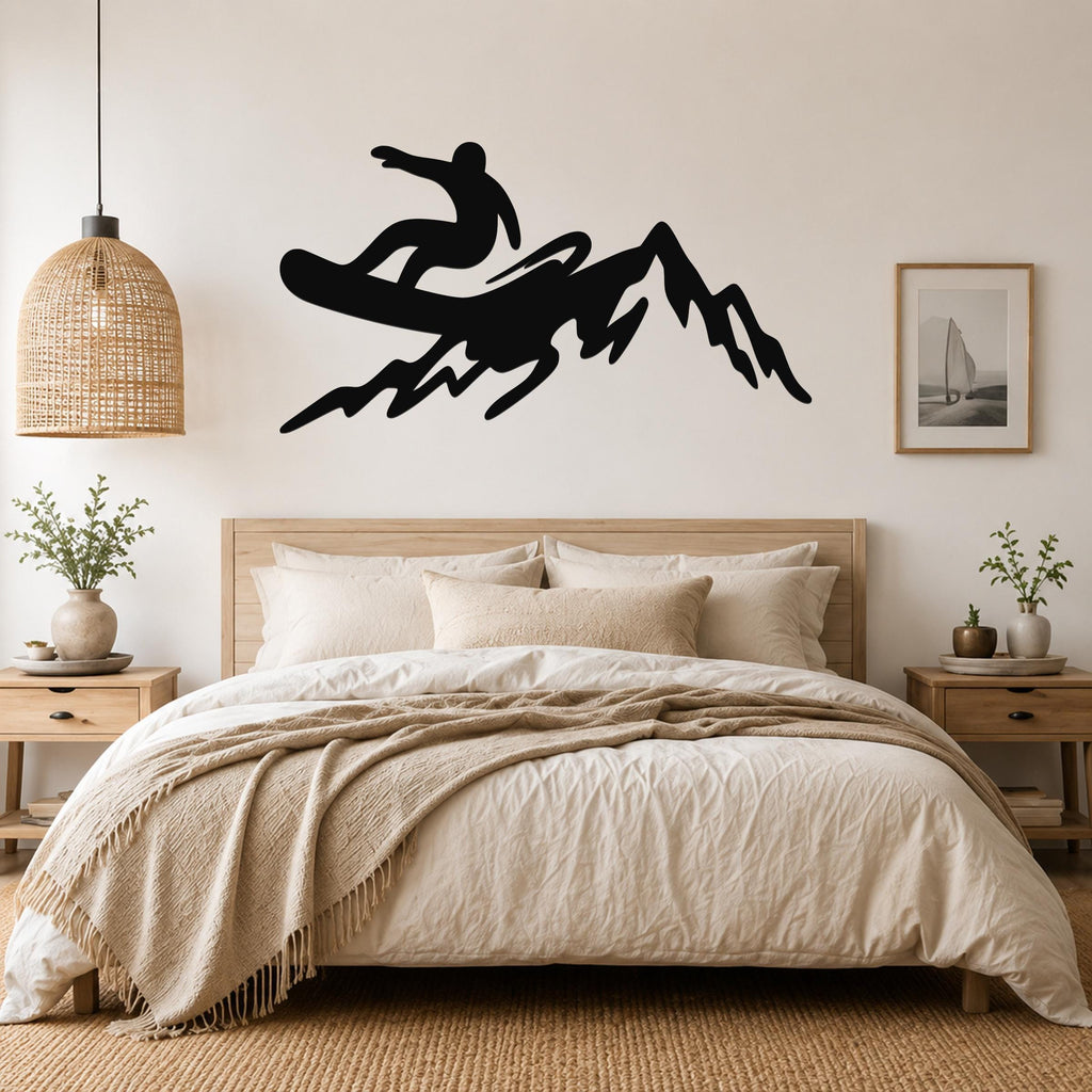 Black metal wall art silhouette of a snowboarder on a mountain, mounted above a bed in a bedroom.
