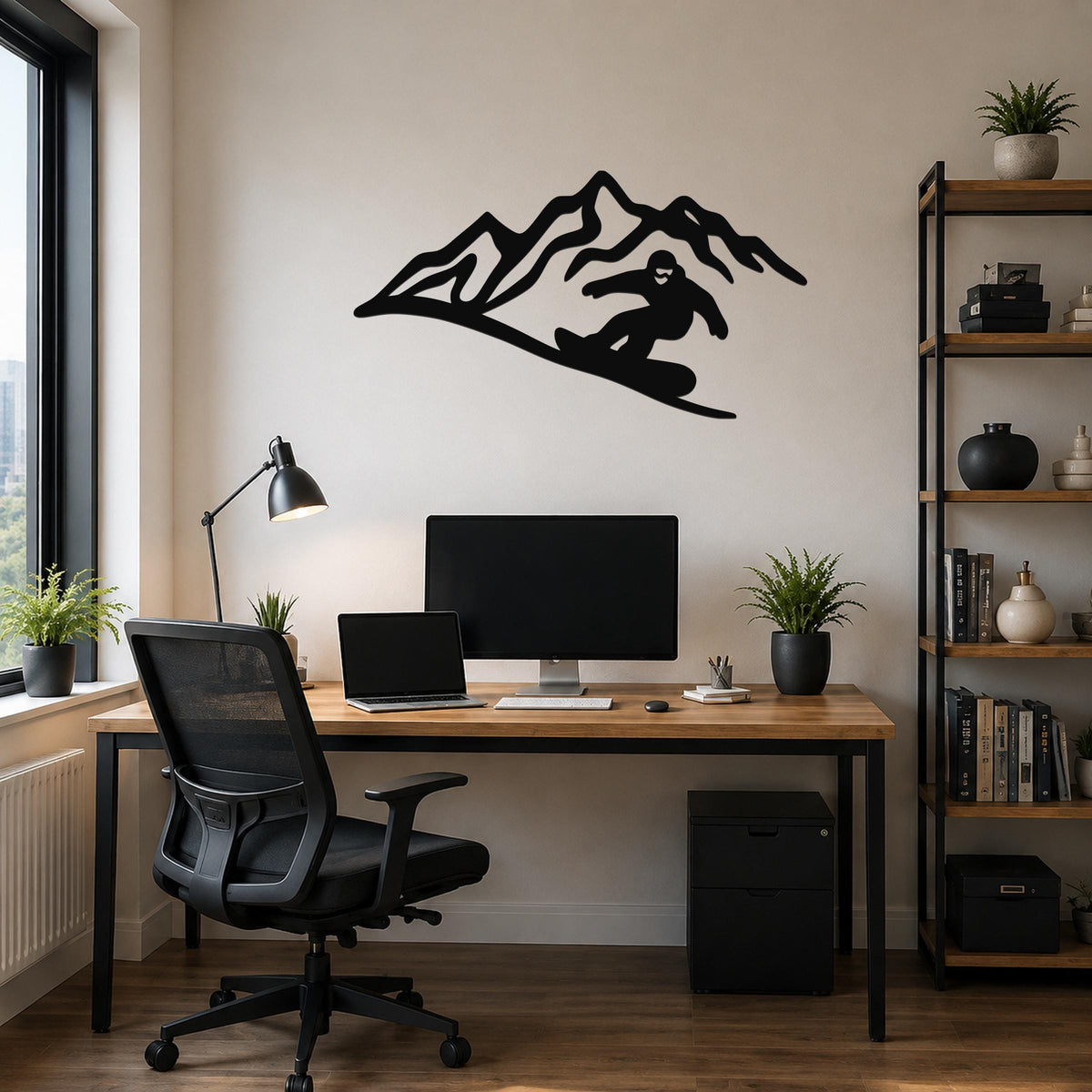 Black metal wall art featuring a snowboarder silhouette descending a mountain, mounted above a wooden desk in a home office.