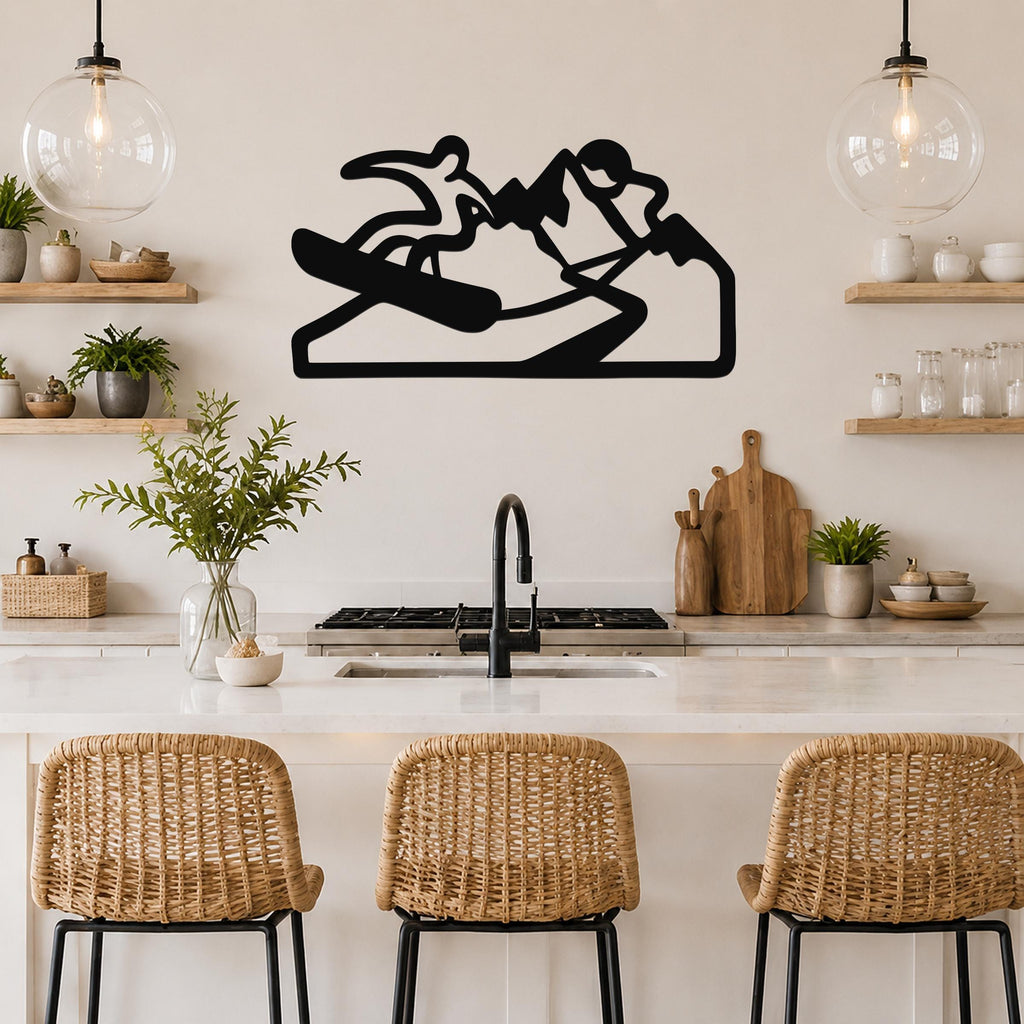 Black metal wall art silhouette of a snowboarder in motion, mounted above a kitchen counter with open shelves and pendant lights.