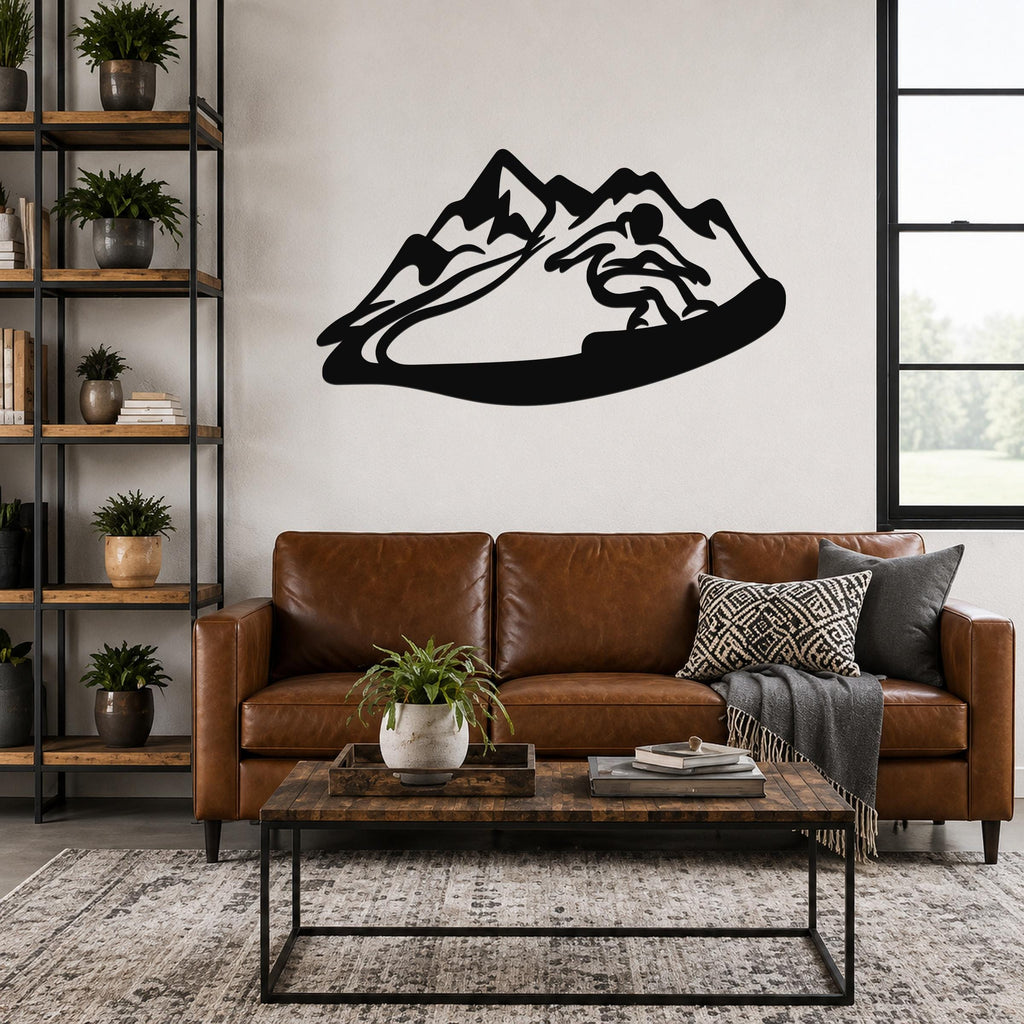 Black metal wall art with a snowboarder silhouette cutting through a mountain range, mounted above a brown leather sofa in a living room.