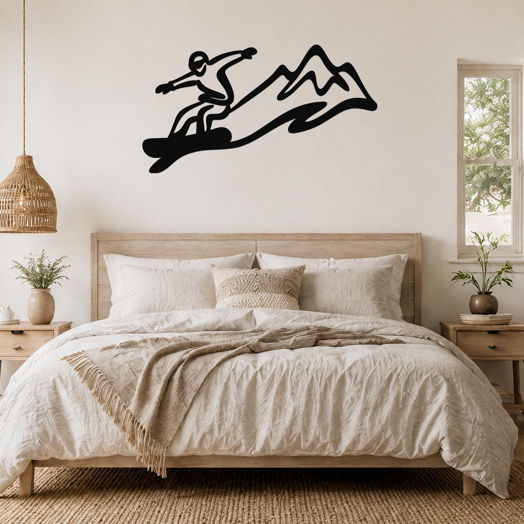 Black metal snowboarder wall art with mountain silhouette, mounted above a bed in a bedroom.