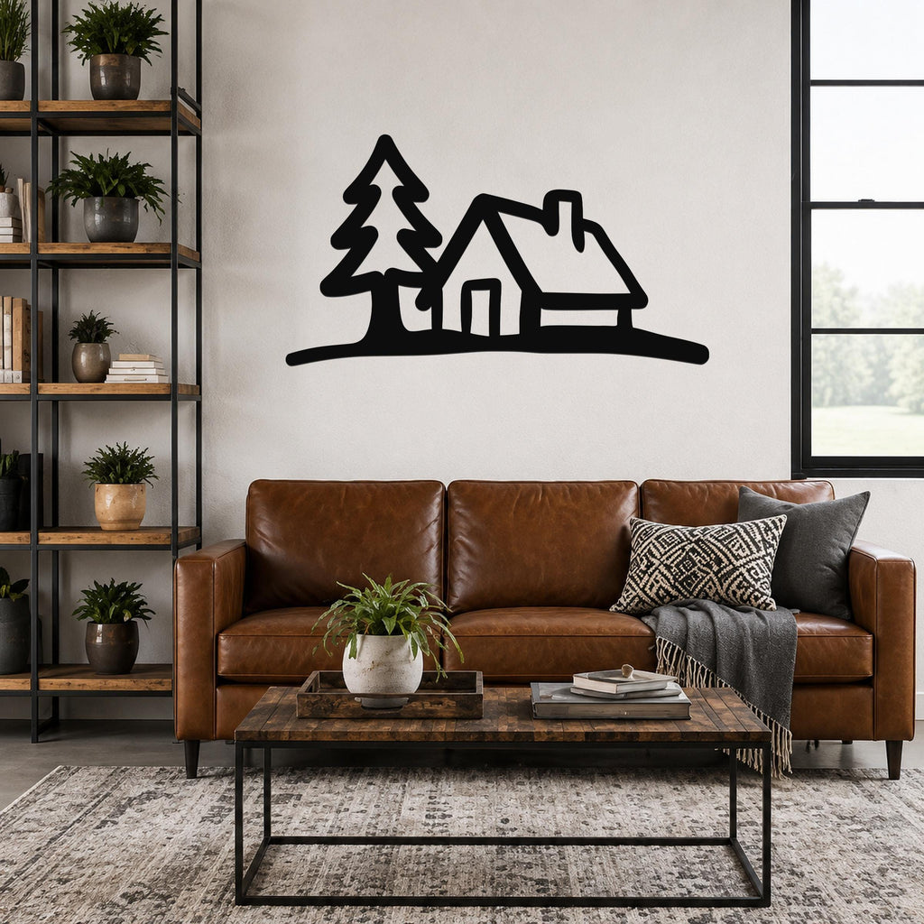 Black metal wall art silhouette of a cabin and tree, mounted above a brown leather sofa in a living room.