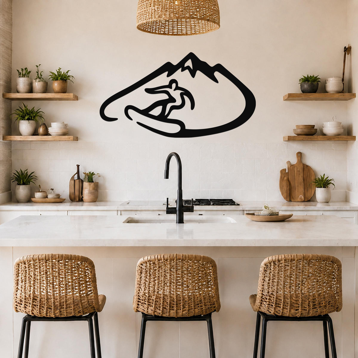 Black metal wall art featuring a minimalist silhouette of a snowboarder in a mountain, mounted above a kitchen counter with wicker stools and wooden shelves.