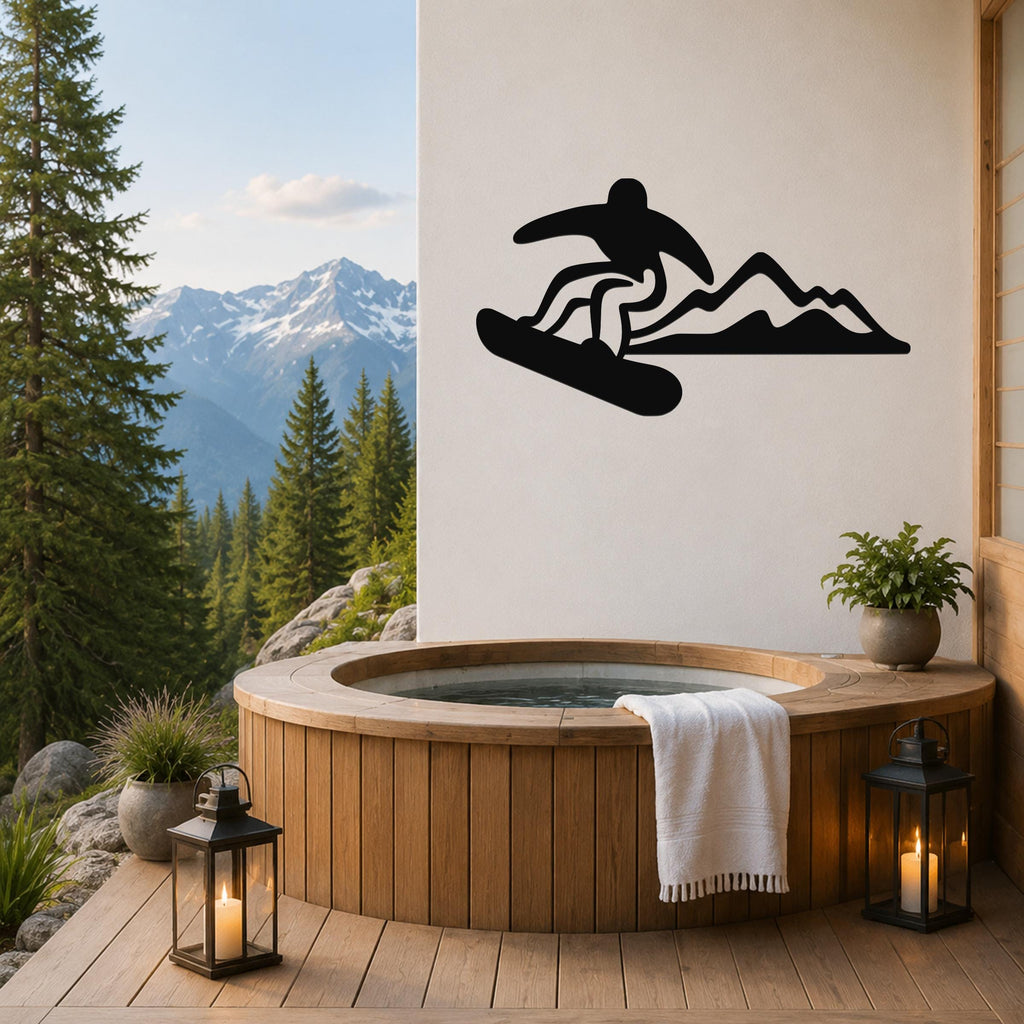 Black metal wall art silhouette of a snowboarder in motion above a mountain range, mounted on a white wall above a wooden hot tub on a deck with a mountain view.