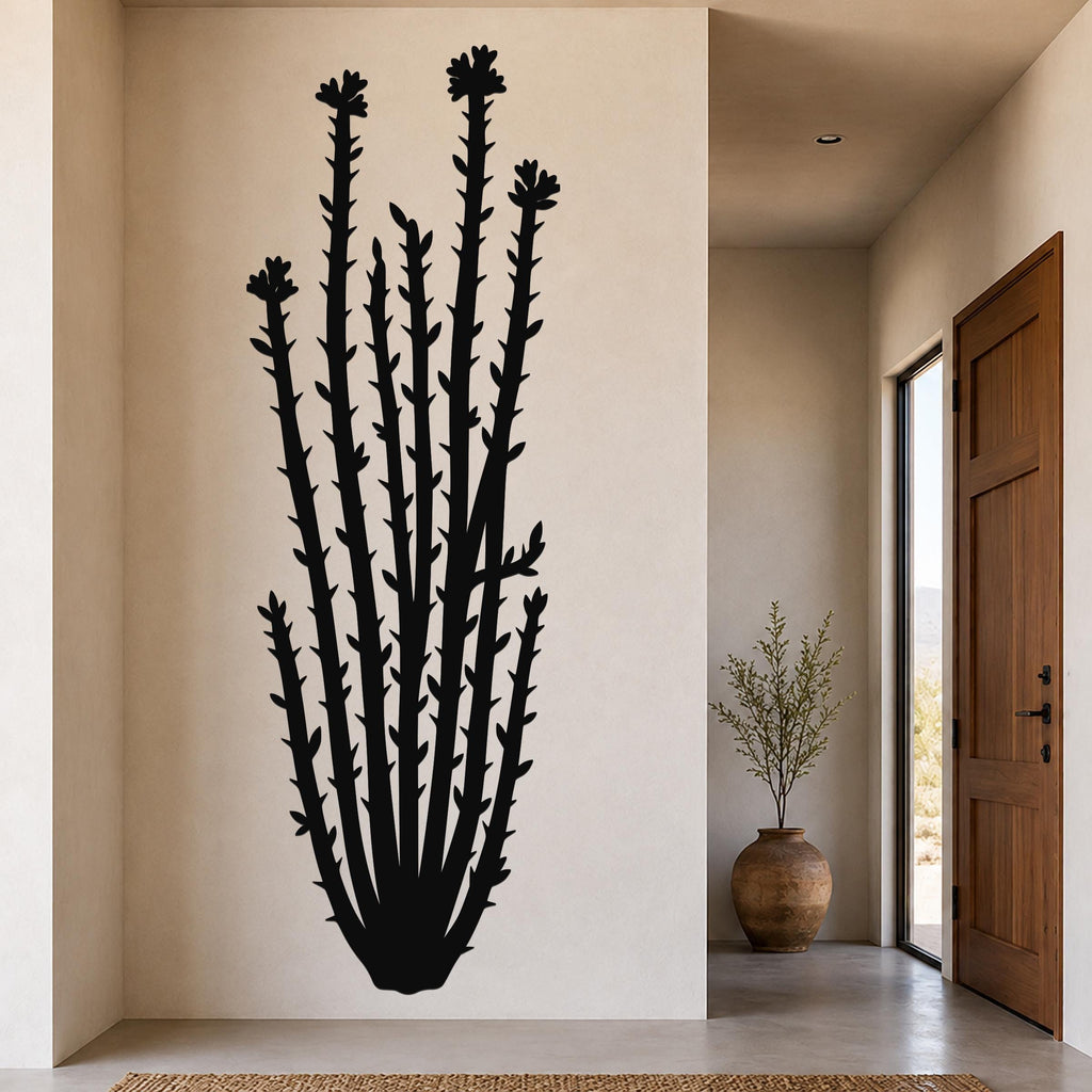 Black metal ocotillo wall art with spiny stems and flower cutouts, mounted on a beige wall in a modern entryway.