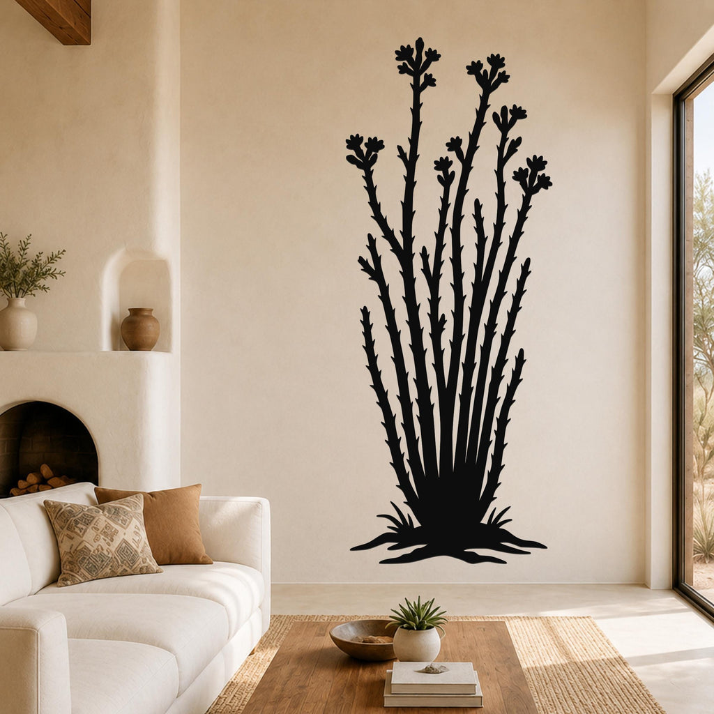 Black metal ocotillo wall art with flower and branch cutouts, mounted on a living room wall above a sofa.