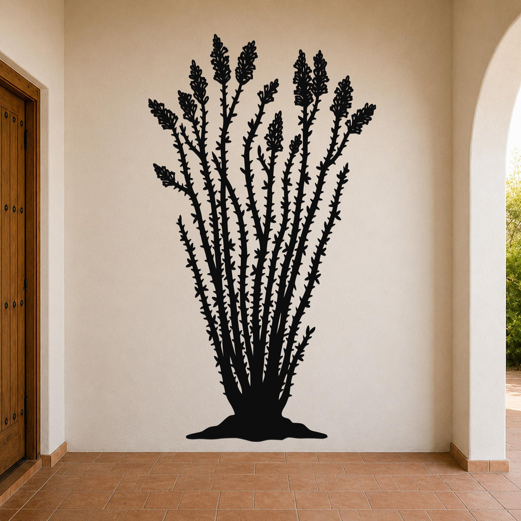Black metal ocotillo wall art silhouette with spiny stems and tubular flower cutouts, mounted on a beige interior wall above terracotta tile flooring.