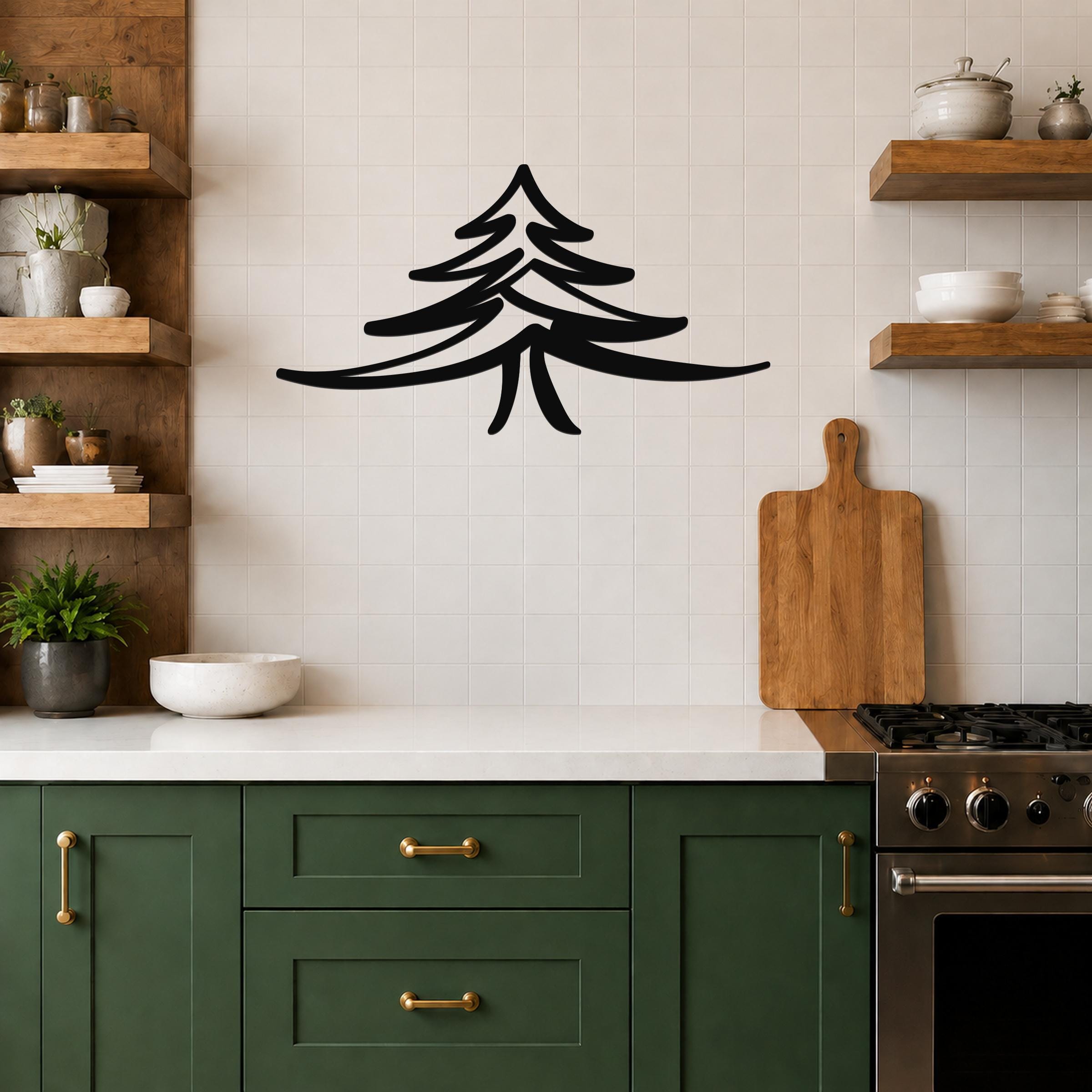 Black metal pine tree wall art with layered branch cutouts, mounted on a tiled kitchen wall above a counter.
