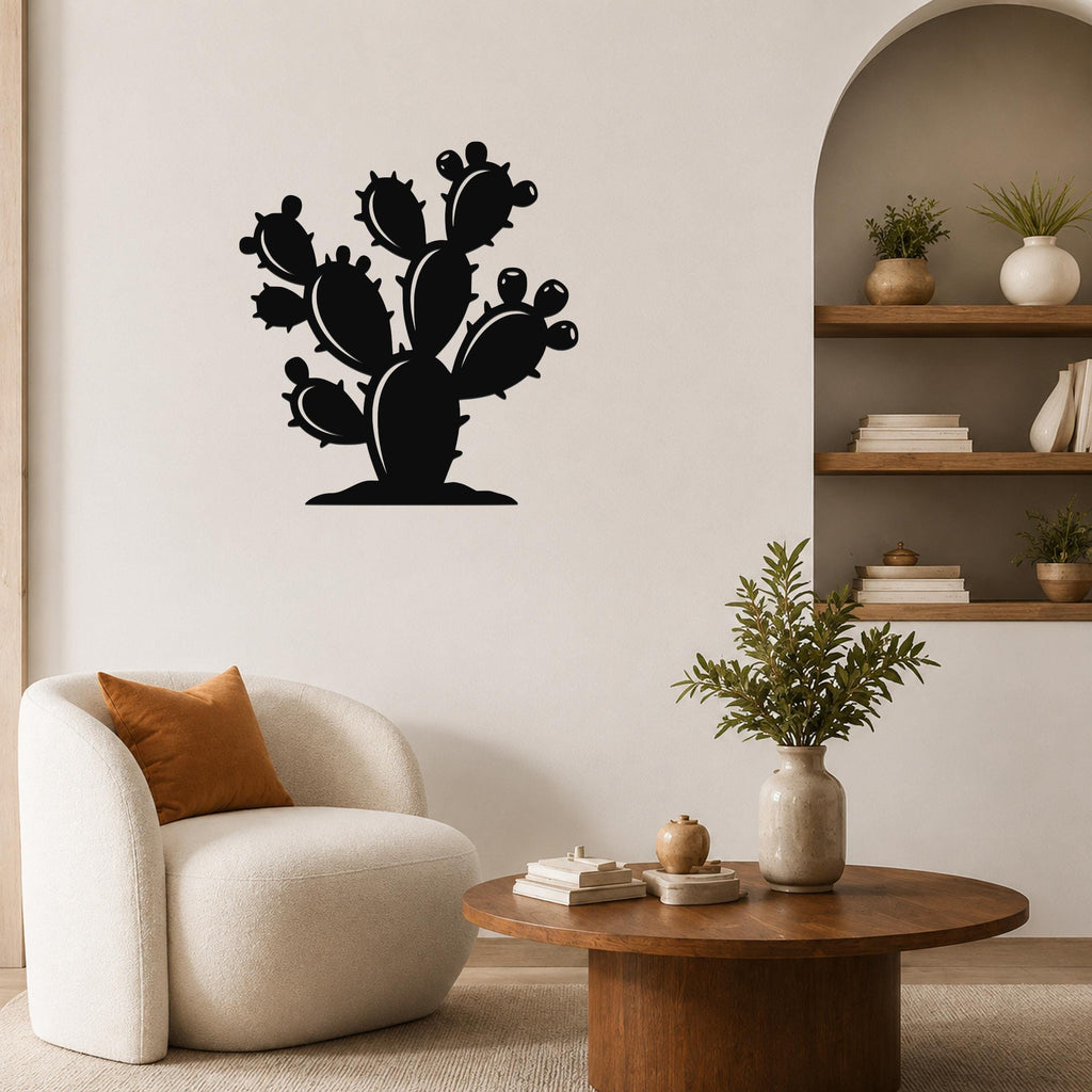 Black metal wall art in the silhouette of a prickly pear cactus with multiple pads and spines, mounted on a living room wall above a round wooden coffee table.