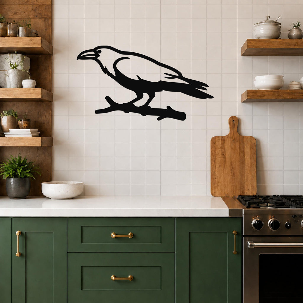 Black metal raven wall art silhouette perched on a branch, mounted on a tiled kitchen wall above a counter.