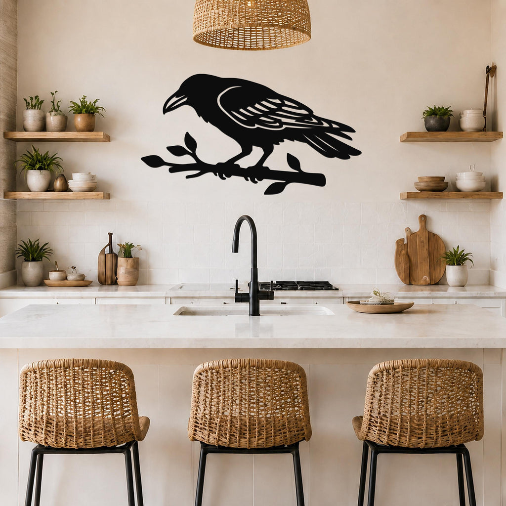 Black metal raven wall art cutout perched on a branch, mounted above a kitchen counter with wicker stools and wooden shelves.