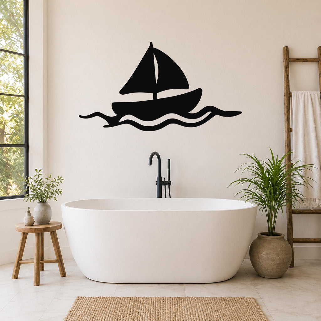 Black metal sailboat wall art with wave cutouts, mounted above a freestanding bathtub in a bright bathroom.