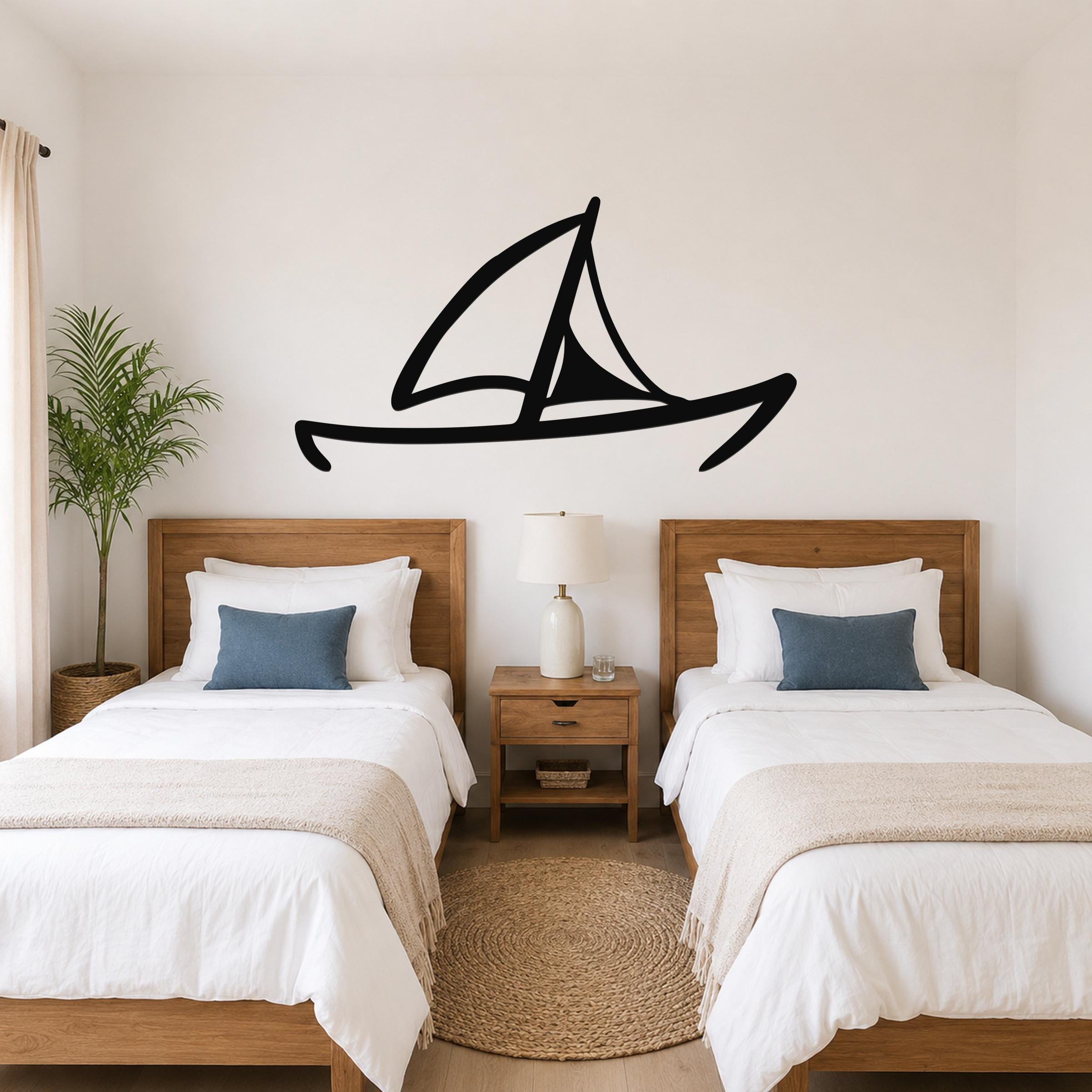Black metal sailboat wall art silhouette mounted above two twin beds in a coastal-style bedroom.