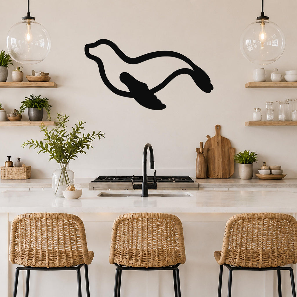 Black metal sea lion wall art with motion-line cutouts, mounted above a kitchen counter in a modern kitchen.