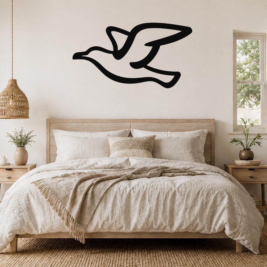 Black metal seagull wall art with motion-line cutouts, mounted above a bed in a neutral bedroom.