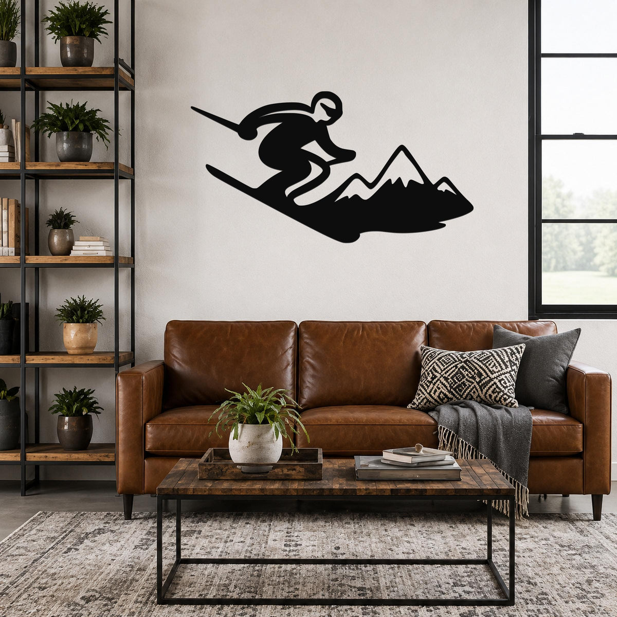 Black metal wall art silhouette of a skier in motion above a mountain, mounted on a living room wall above a brown leather sofa.