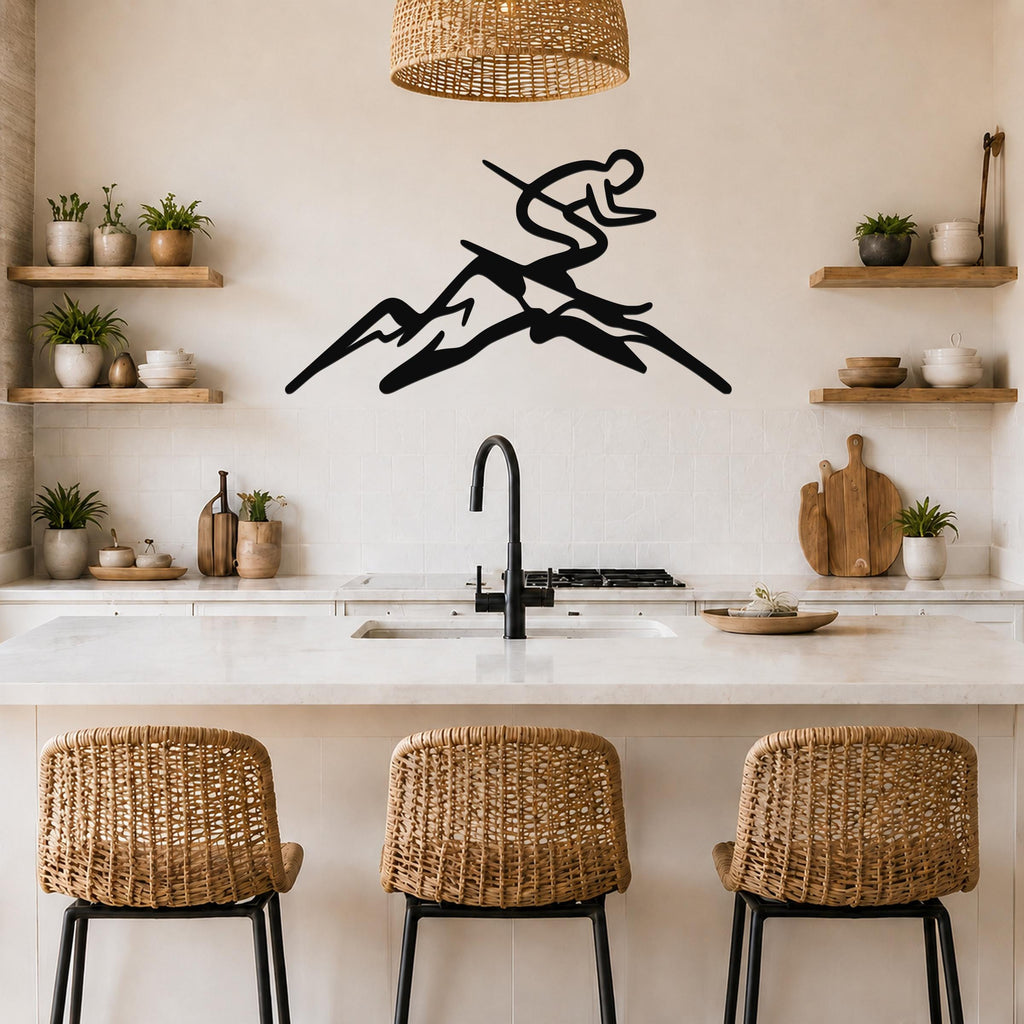 Black metal wall art featuring a skier silhouette in motion above a mountain range, mounted on a kitchen wall above a counter.