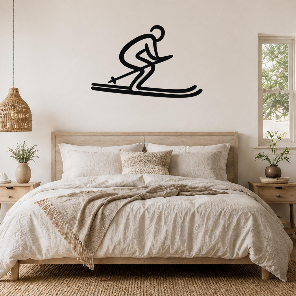 Black metal wall art of a skier silhouette with motion lines, mounted above a bed in a bedroom.