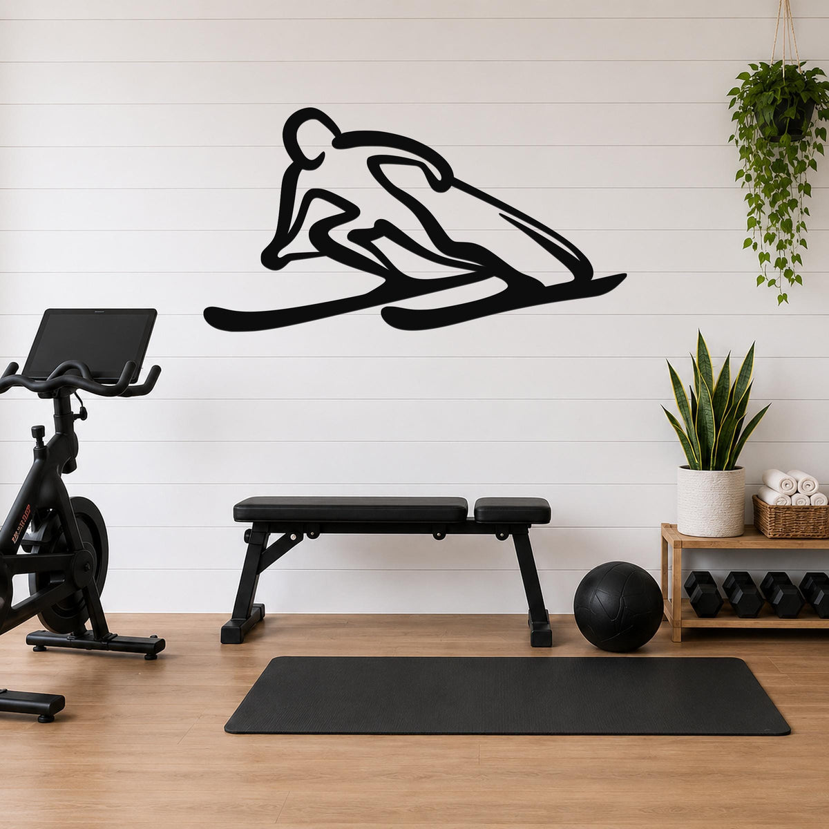 Black metal wall art of a skier silhouette with motion lines, mounted on a white shiplap wall above a workout bench in a home gym.