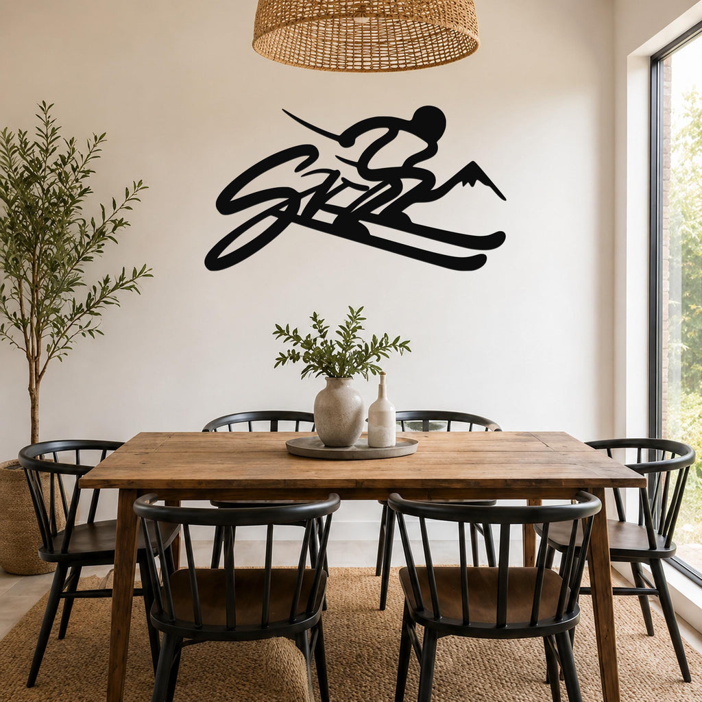 Black metal wall art featuring a skier silhouette with mountain and ski cutouts, mounted above a wooden dining table in a bright room.