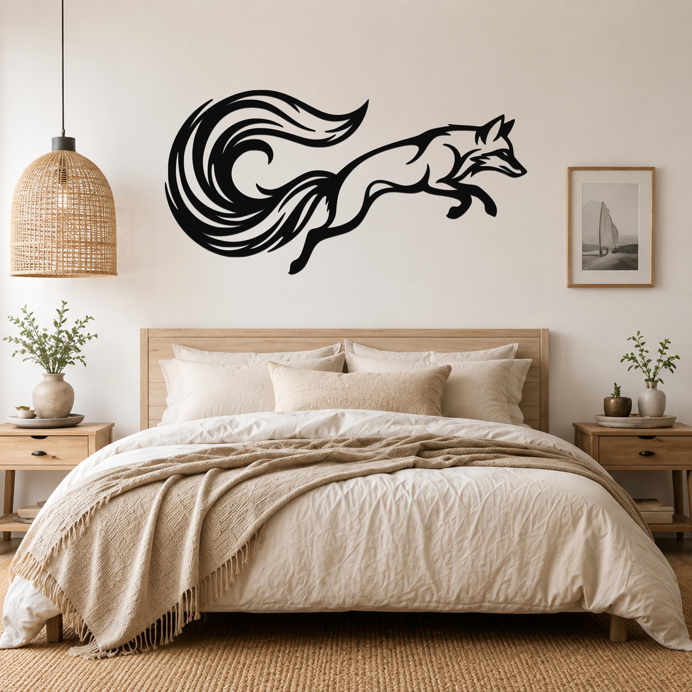 Black metal fox wall art with a swirling tail silhouette, mounted above a bed in a neutral bedroom.