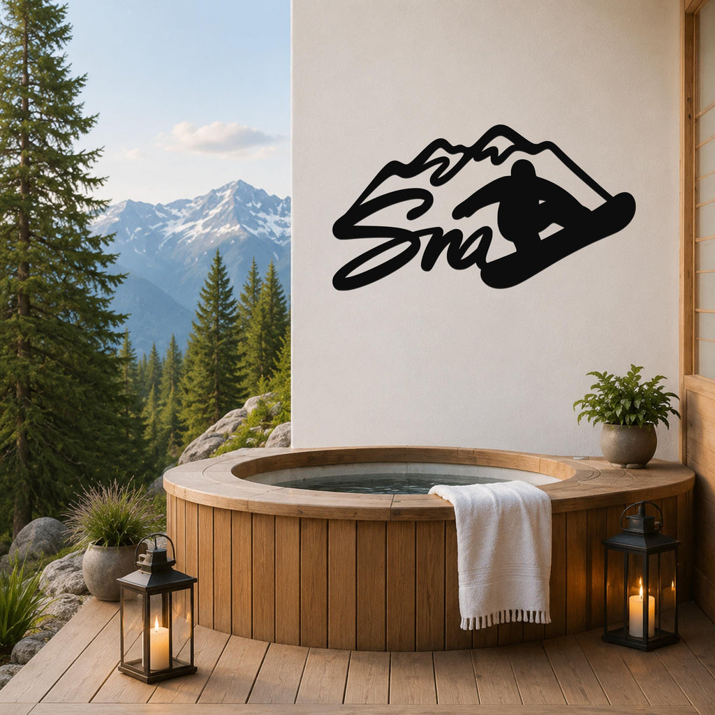 Black metal wall art featuring a snowboarder silhouette and mountain design, mounted on a white wall above a wooden hot tub on a deck with a mountain view.