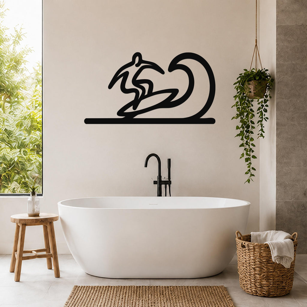 Black metal surfer wall art with wave silhouette, mounted above a freestanding bathtub in a modern bathroom.