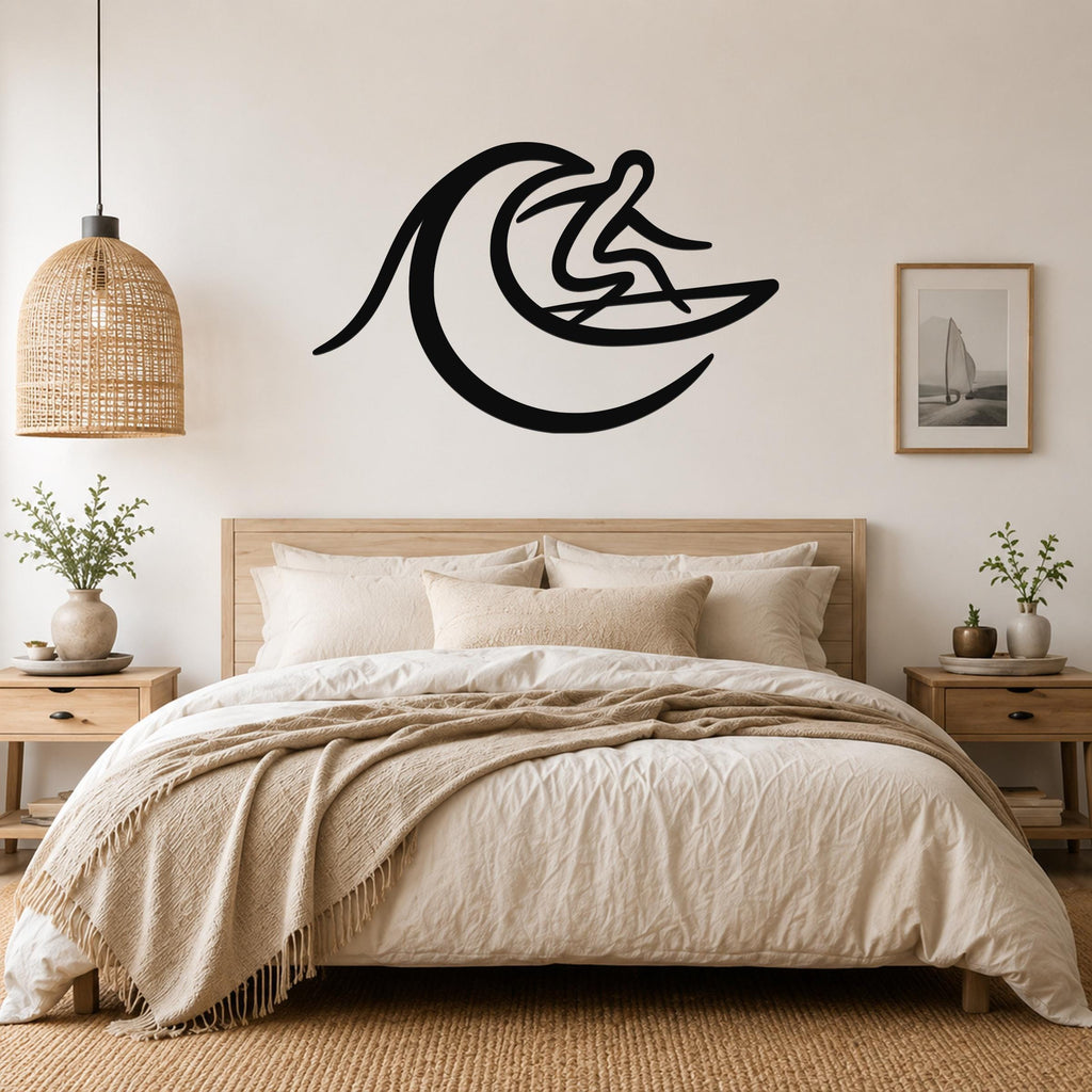 Black metal wall art in a silhouette of a surfer riding a wave, mounted above a bed in a bedroom.