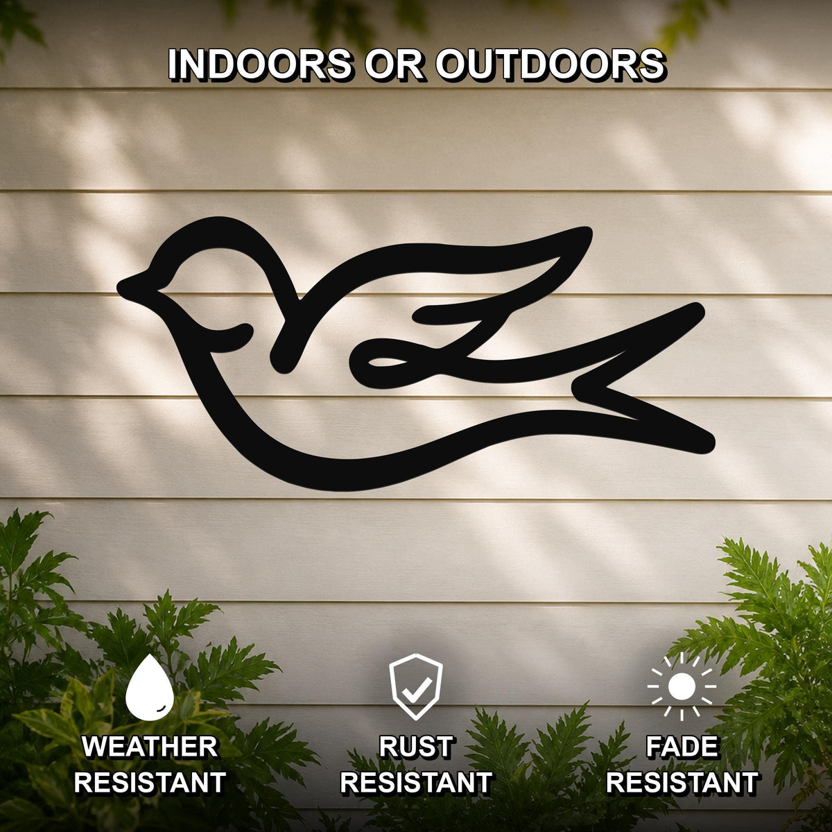 Black metal swallow bird wall art with a graceful silhouette, mounted on a light-colored outdoor wall with greenery, weather resistant, rust resistant, and fade resistant.