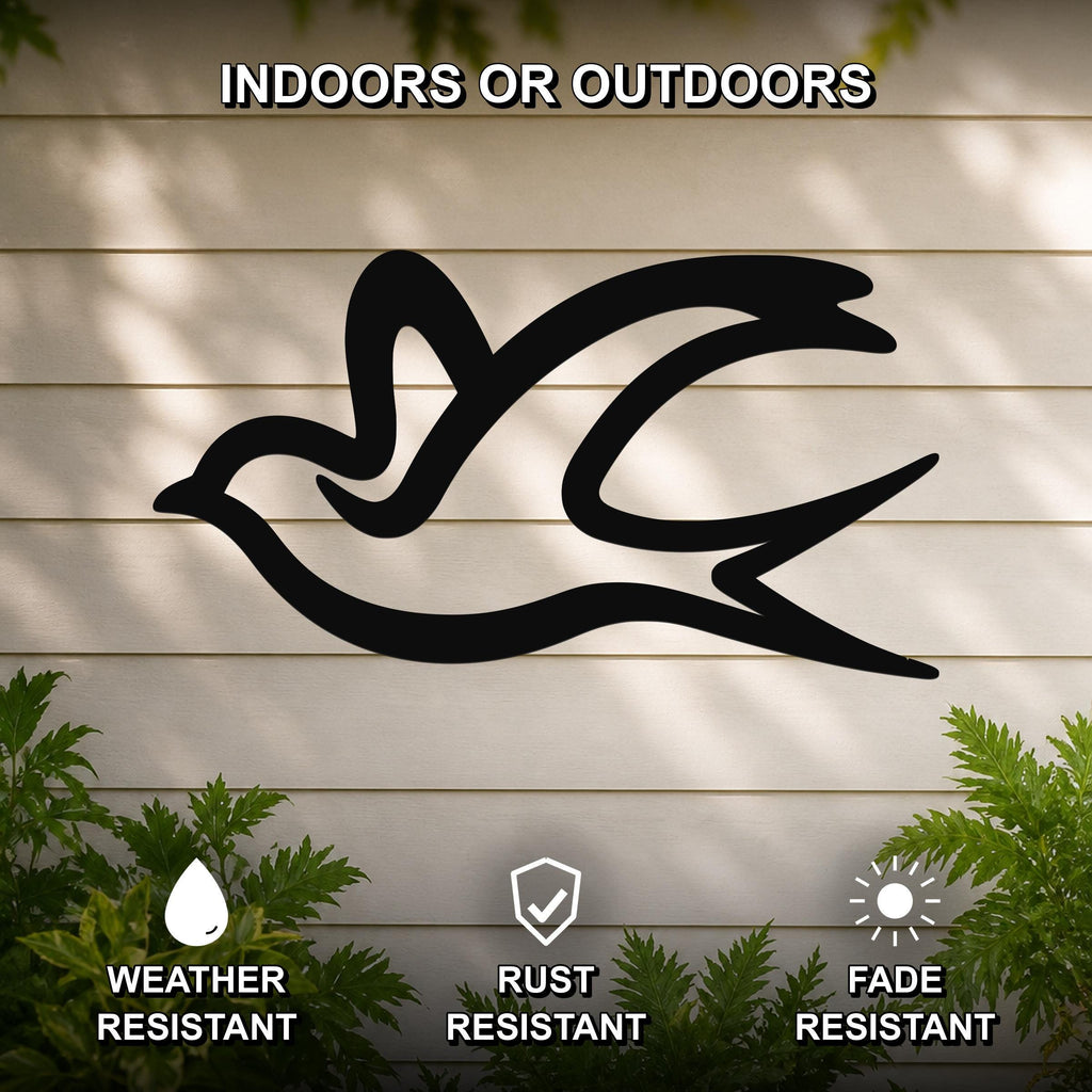 Black metal swallow bird wall art silhouette mounted on a beige outdoor wall, weather resistant, rust resistant, and fade resistant, with green foliage at the base.