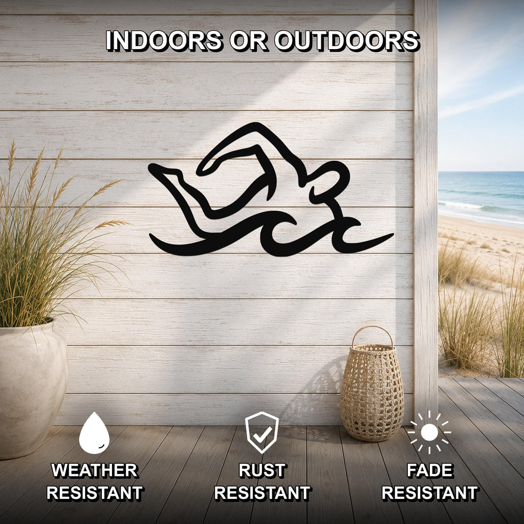 Black metal swimmer wall art with fluid motion cutouts, mounted on a light wood wall above a deck with a beach view.