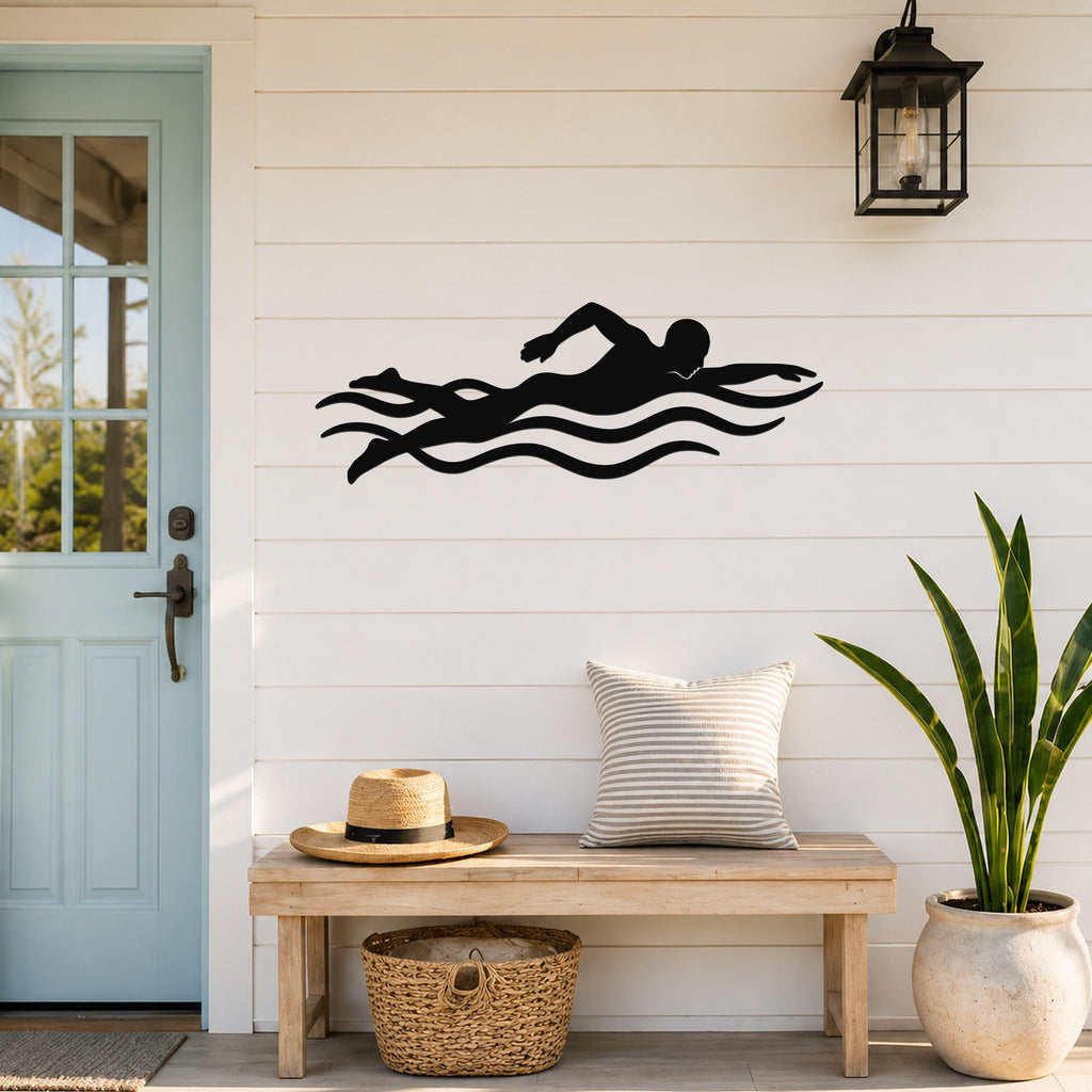 Black metal swimmer wall art with motion-line cutouts, mounted on a white shiplap wall above a wooden bench in a porch entryway.