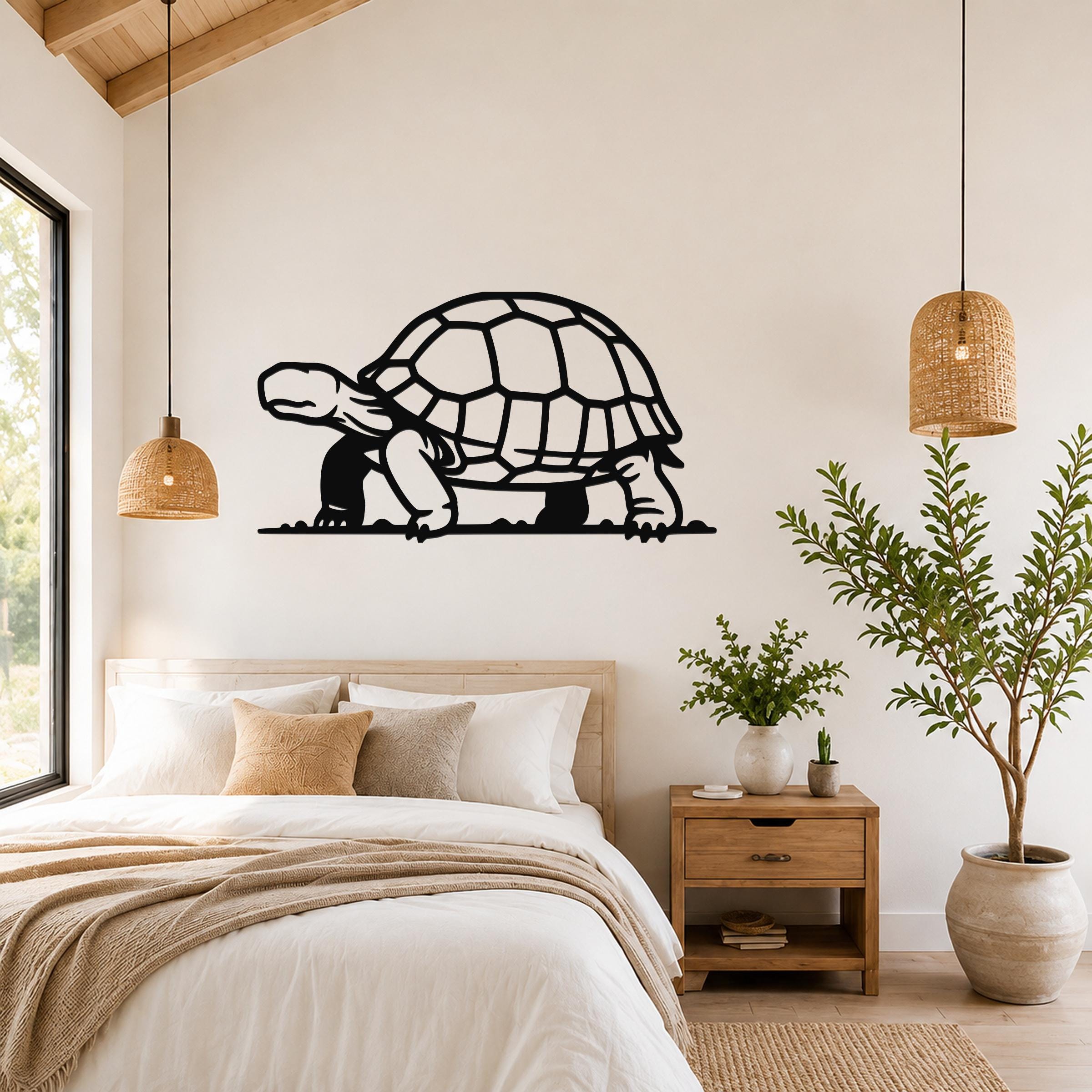 Black metal tortoise wall art with a cutout shell and legs, mounted above a bed in a bright bedroom.