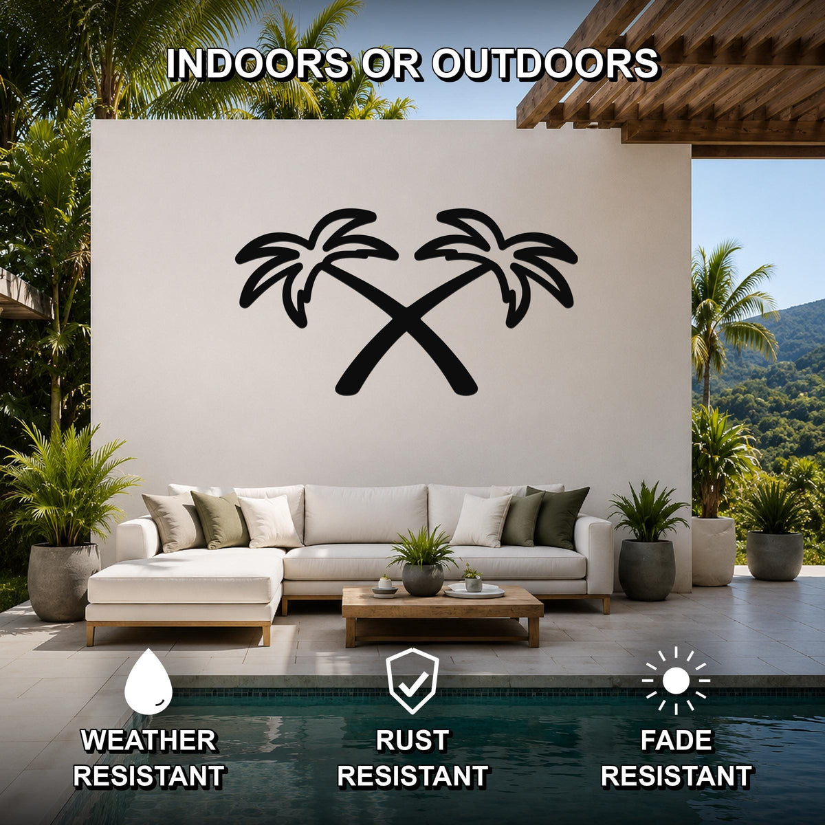 Black metal wall art featuring a silhouette of two crossed palm trees, mounted on a white outdoor wall above a sofa in a patio living area.