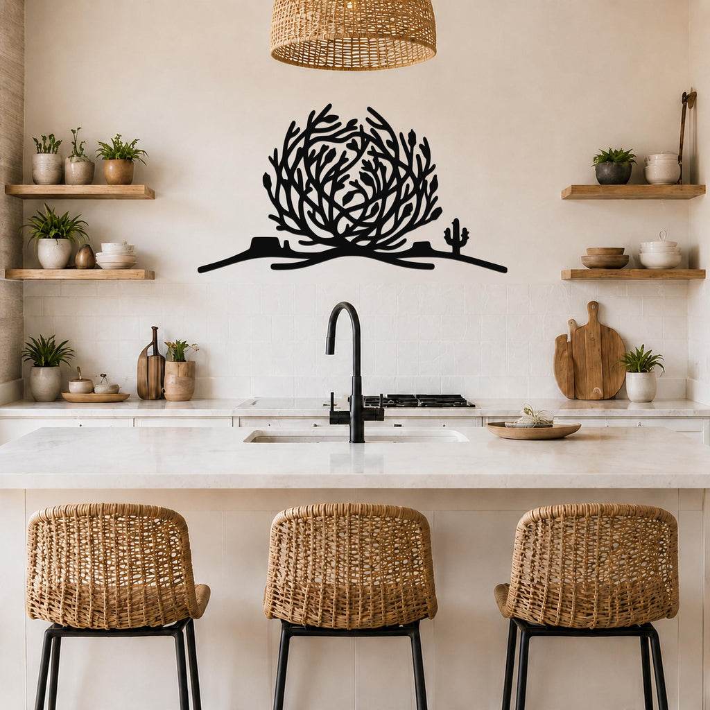 Black metal tumbleweed wall art with cactus silhouette, mounted above a kitchen counter in a neutral-toned kitchen.