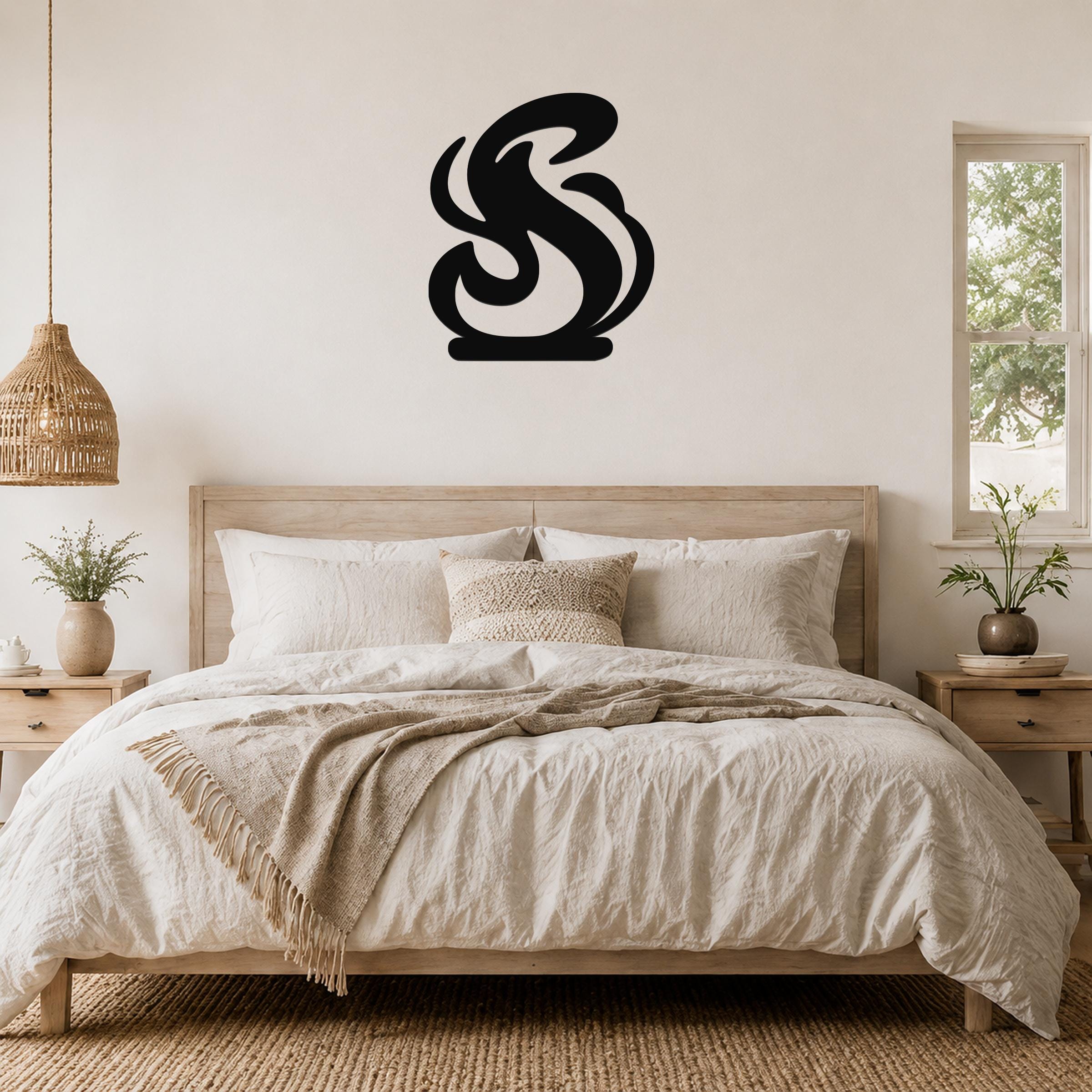 Black metal wall art in a flowing flame silhouette, mounted above a bed in a neutral bedroom.