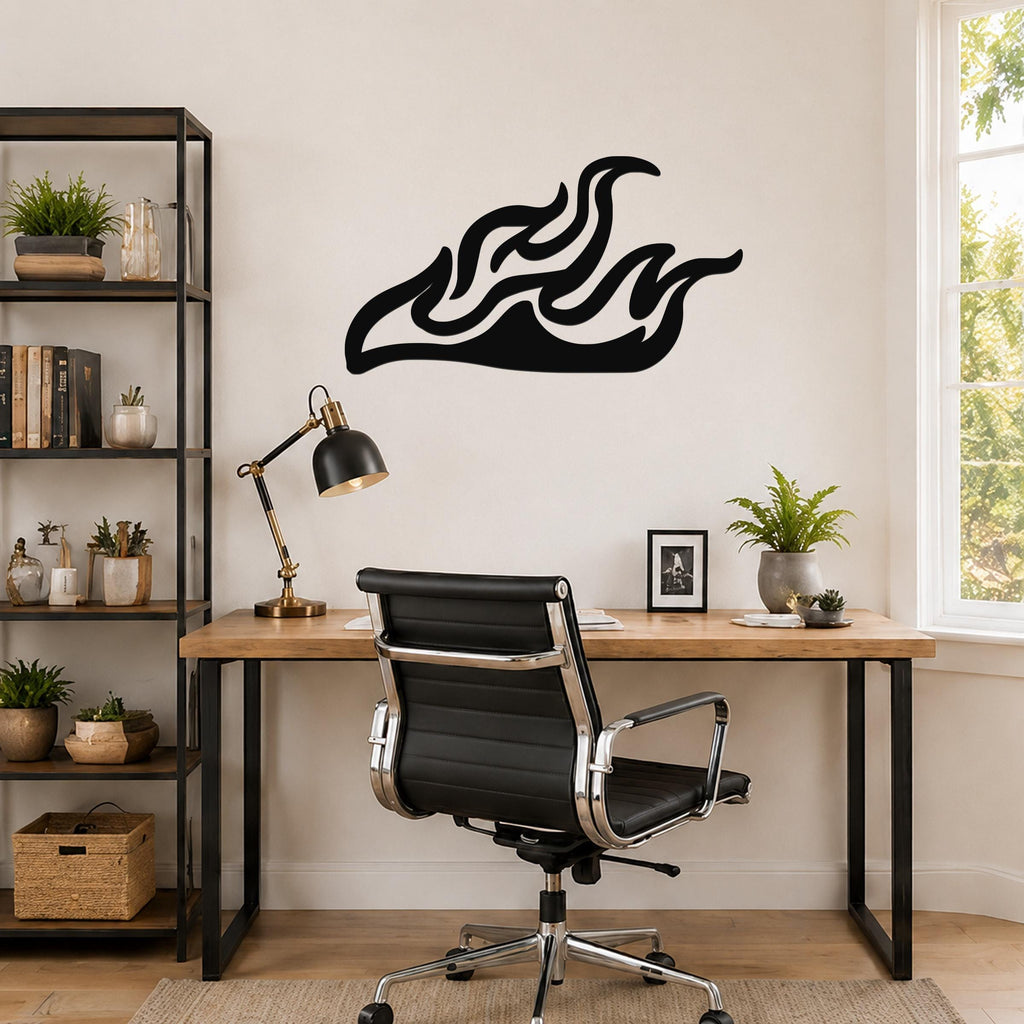Black metal flame wall art with flowing silhouette cutouts, mounted above a wooden desk in a home office.