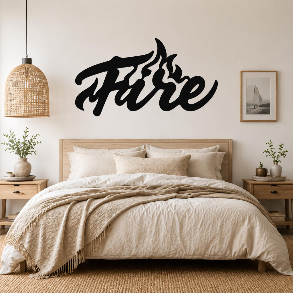 Black metal wall art with the word "Fire" in a flowing script, featuring flame-like cutouts on the letter 'F', mounted above a bed in a neutral bedroom.