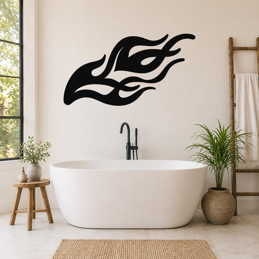 Black metal flame wall art with flowing silhouette cutouts, mounted on a bathroom wall above a freestanding tub.