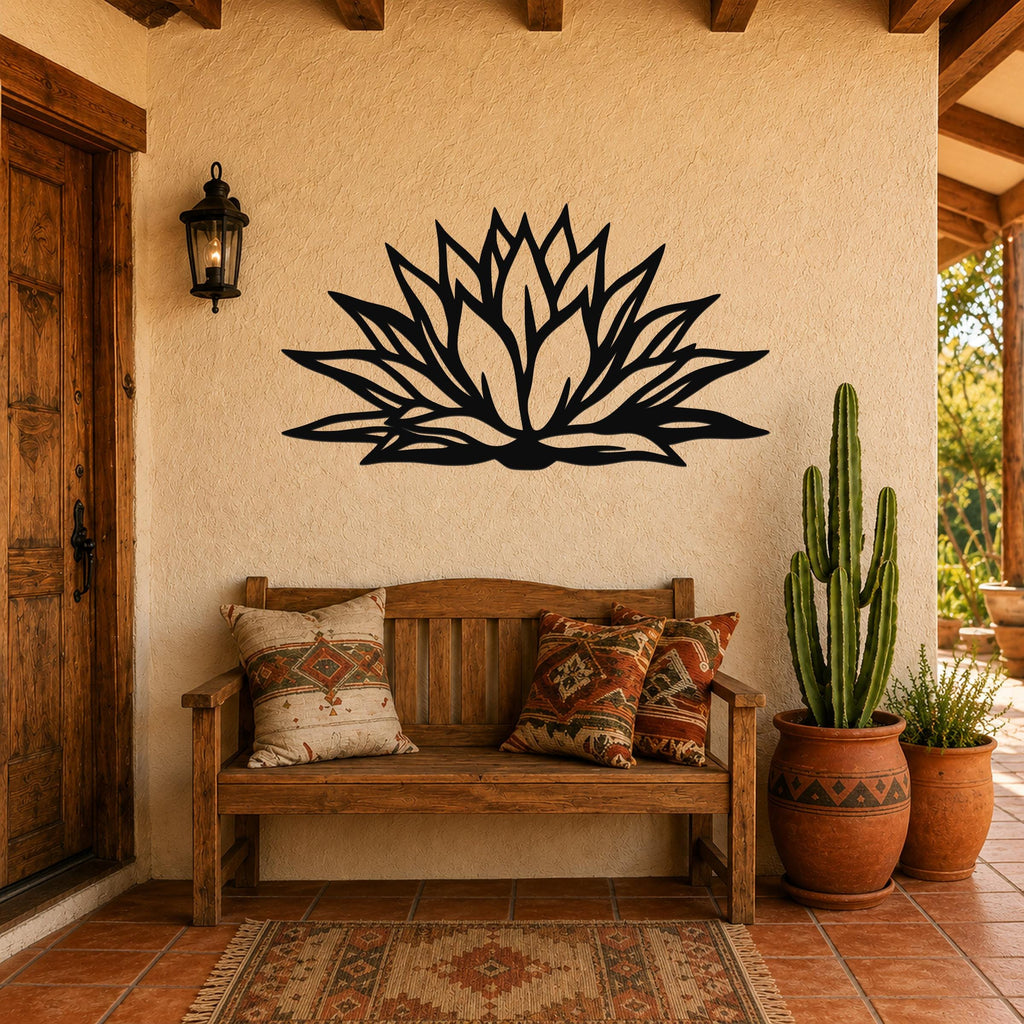 Black metal agave wall art with bold geometric cutouts, mounted on a stucco wall above a wooden bench in a patio entryway.