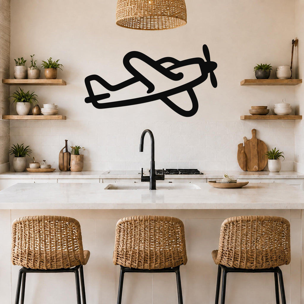 Black metal airplane wall art silhouette with propeller and wing cutouts, mounted on a kitchen wall above a counter.
