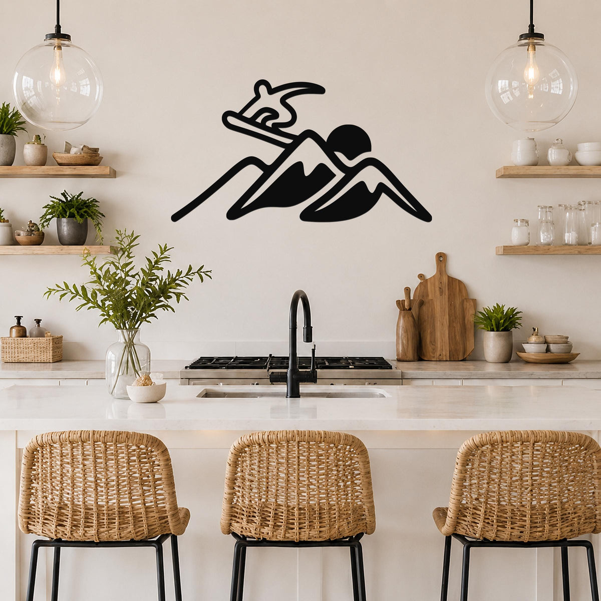 Black metal wall art silhouette of a snowboarder on a mountain, mounted above a kitchen counter with wicker bar stools.
