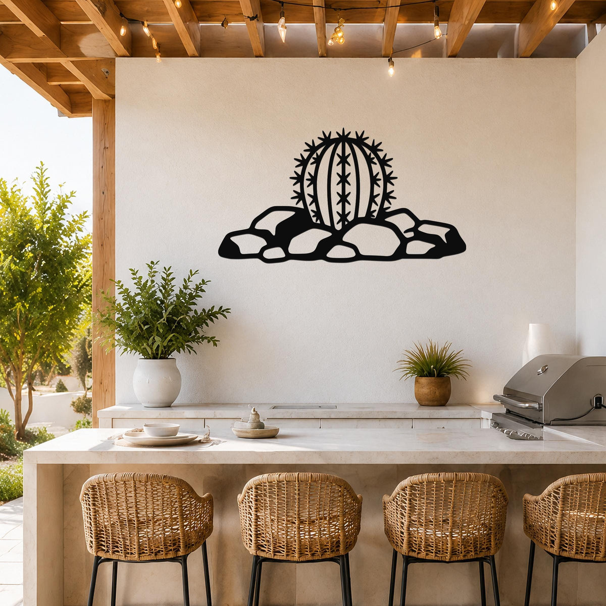 Black metal barrel cactus wall art with spines and rock cutouts, mounted on a white wall above a kitchen counter.