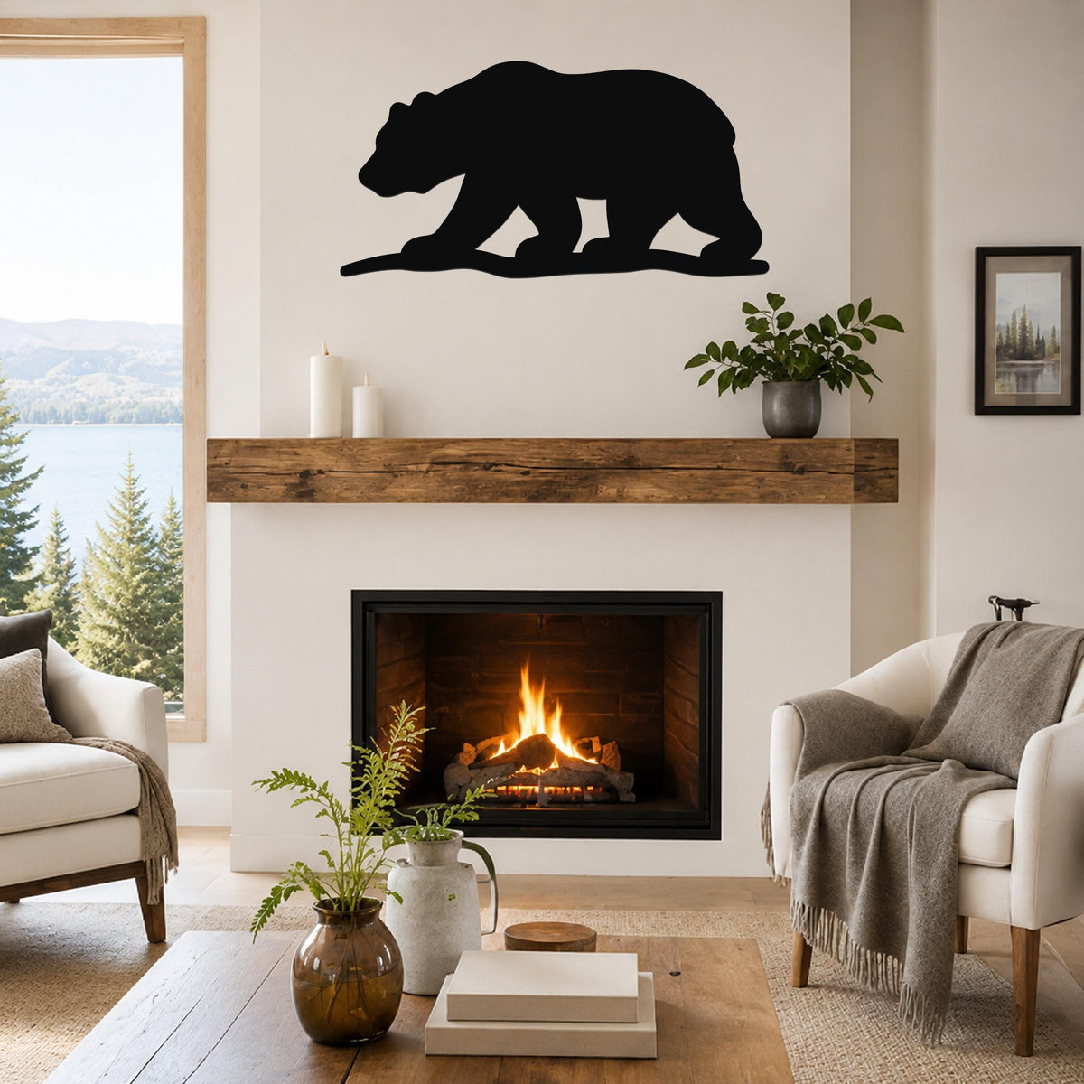Black metal bear silhouette wall art mounted above a fireplace in a living room with a lake view.