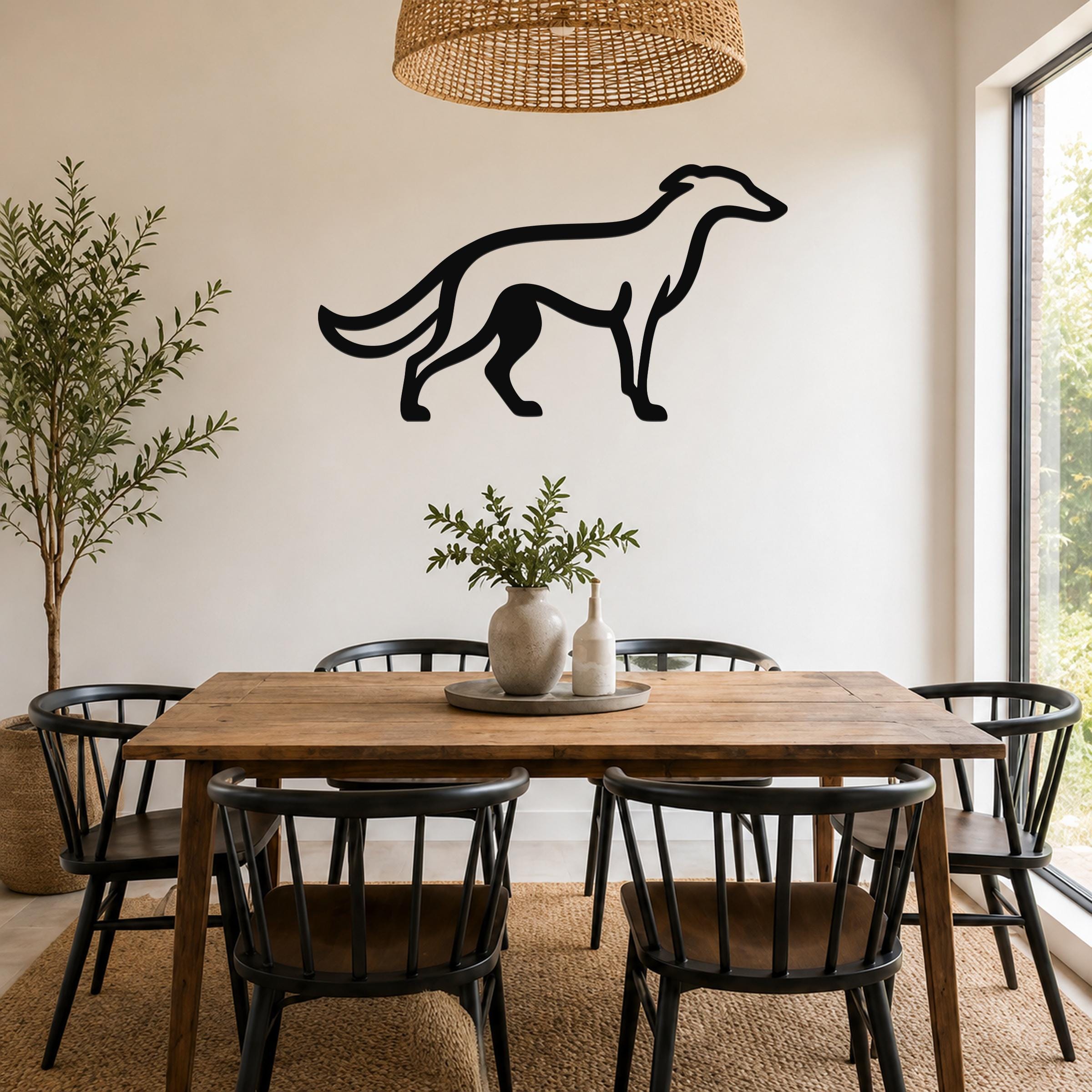 Black metal Borzoi dog wall art silhouette mounted on a white wall above a wooden dining table in a bright dining room.