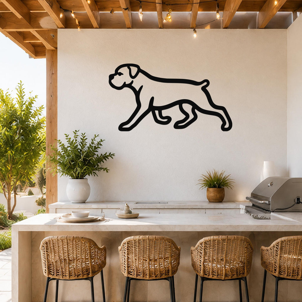Black metal Boxer dog silhouette wall art mounted on a white outdoor wall above a kitchen counter with wicker bar stools.