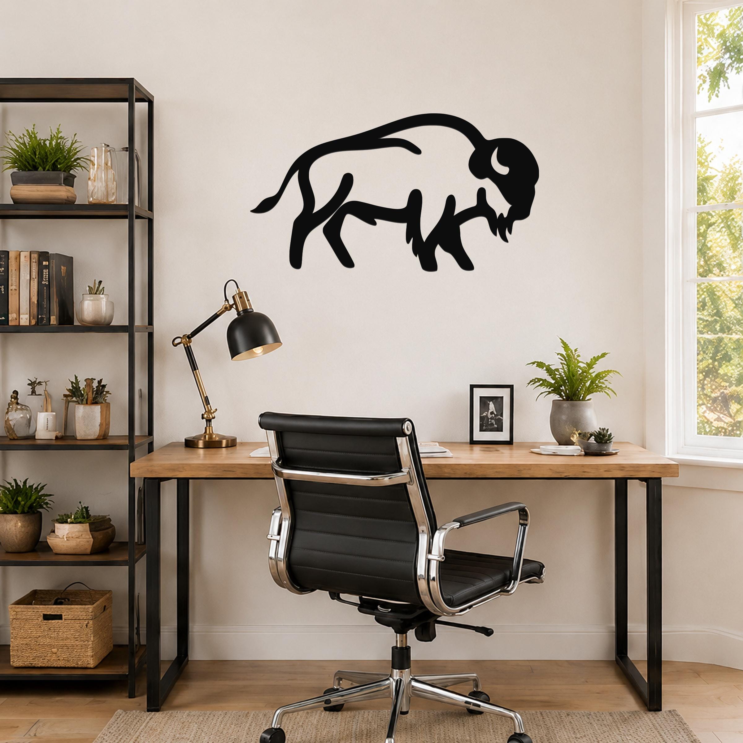 Black metal buffalo silhouette wall art mounted above a wooden desk in a home office.
