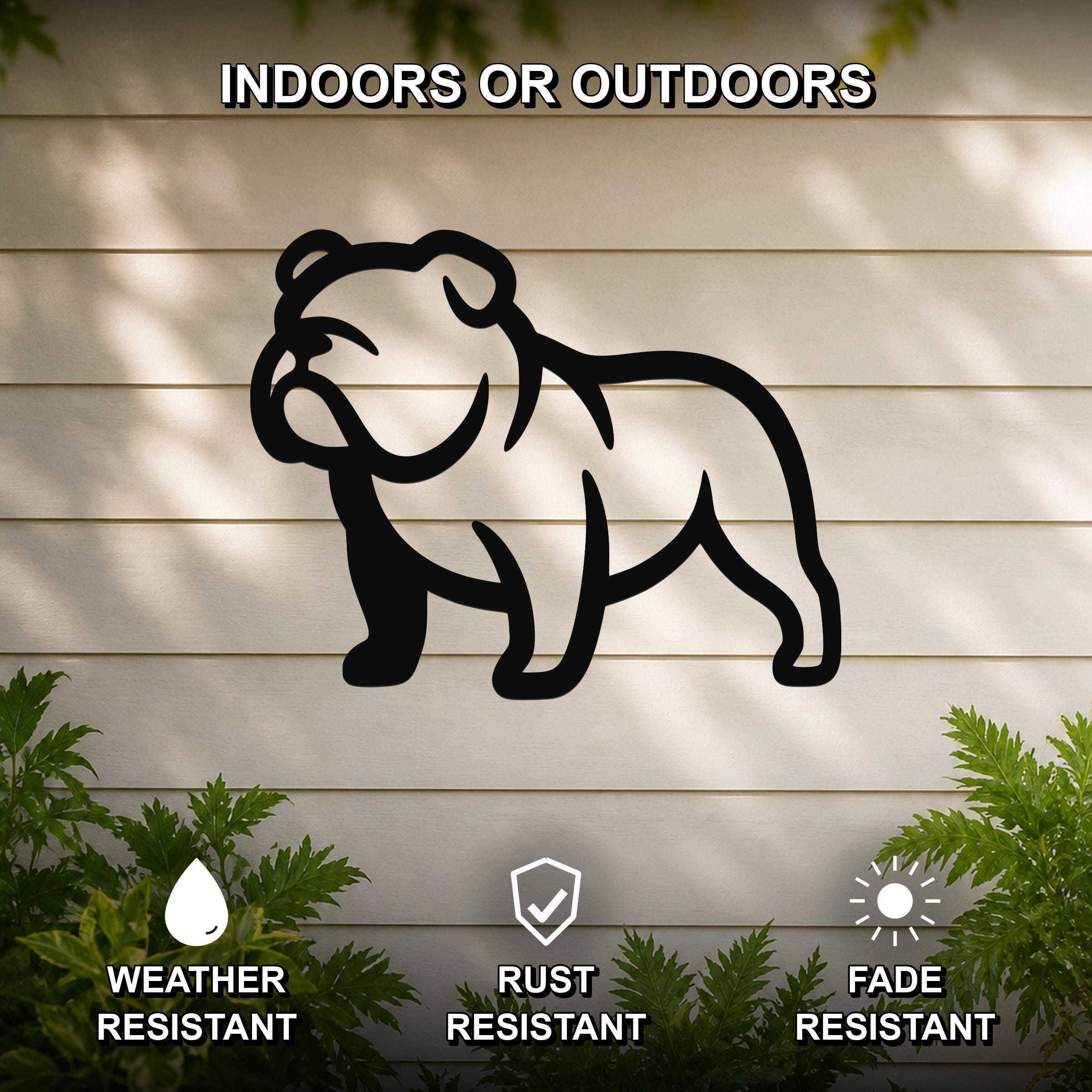 Black metal bulldog silhouette wall art mounted on a light-colored outdoor wall, with green plants at the base and text indicating it is weather, rust, and fade resistant.
