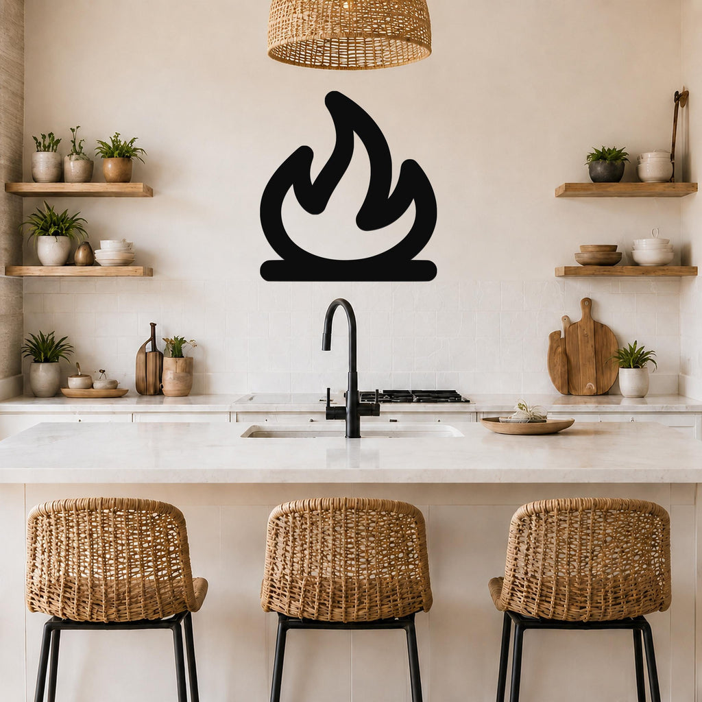 Black metal campfire silhouette wall art mounted on a kitchen wall above a counter, with a wicker pendant light and wooden shelves visible.